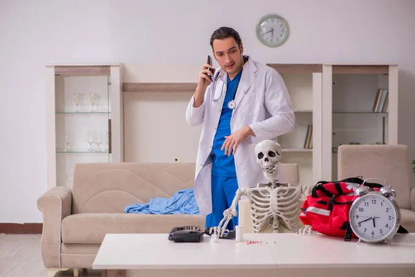 Joven paciente masculino paramédico visitando esqueleto —  Fotos de Stock