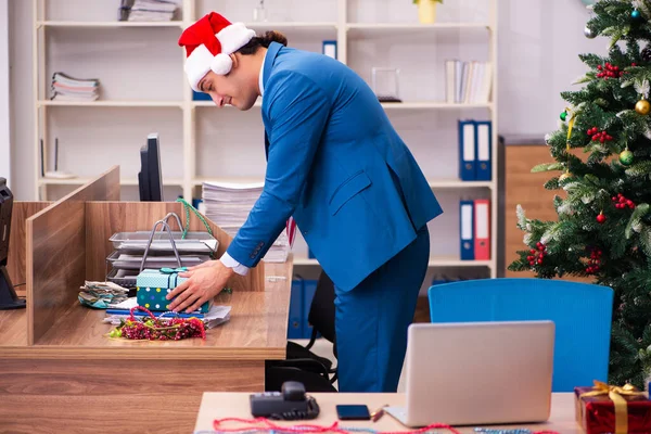 Ung mandlig medarbejder fejrer jul på arbejdspladsen - Stock-foto