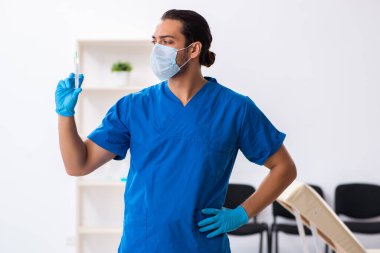 Klinikte çalışan genç erkek doktor.