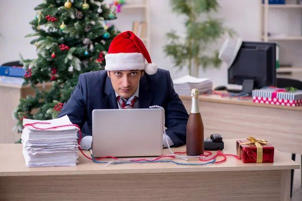 Young male employee celebrating new year in the office