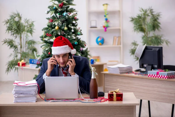 Young male employee celebrating new year in the office