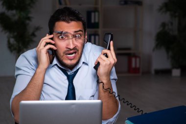 Genç işadamı ofiste geç saatlere kadar çalışıyor.