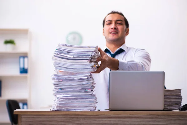 Joven empleado masculino infeliz con el trabajo excesivo — Foto de Stock