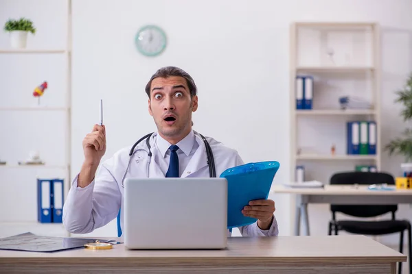 Jovem médico tomando notas no hospital — Fotografia de Stock