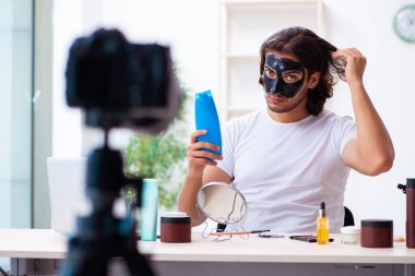 Genç erkek kozmetikçi blogu için video kaydediyor.