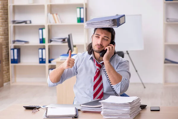 Giovane dipendente maschio infelice con il lavoro eccessivo — Foto Stock