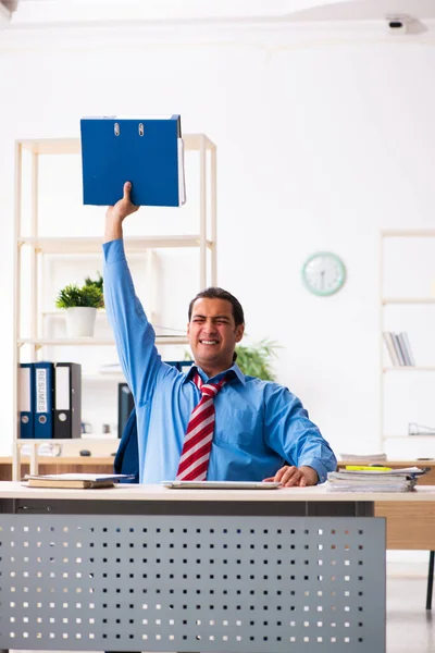 Giovane dipendente maschio che fa esercizi sportivi sul posto di lavoro — Foto Stock