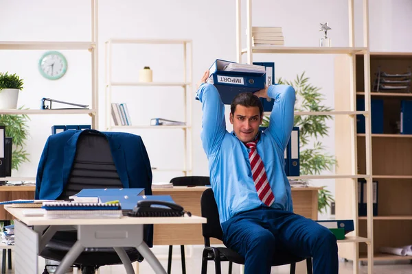 Giovane dipendente maschio che fa esercizi sportivi sul posto di lavoro — Foto Stock