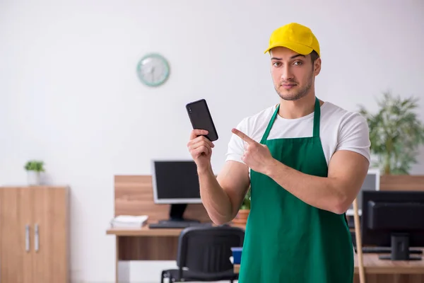 Jonge mannelijke aannemer schoonmaken van het kantoor — Stockfoto