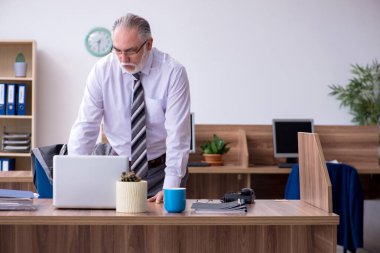 İş yerinde radkülit hastası olan yaşlı bir erkek işçi.