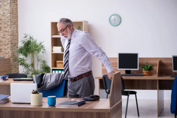 Velho trabalhador masculino que sofre de radiculite no local de trabalho — Fotografia de Stock