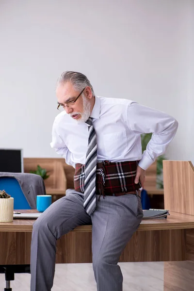 Old male employee suffering from radiculitis at workplace — Stock Photo, Image