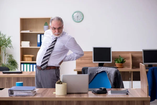 Velho trabalhador masculino que sofre de radiculite no local de trabalho — Fotografia de Stock