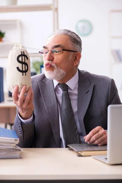 Gammal manlig anställd som håller pengar i pension koncept — Stockfoto