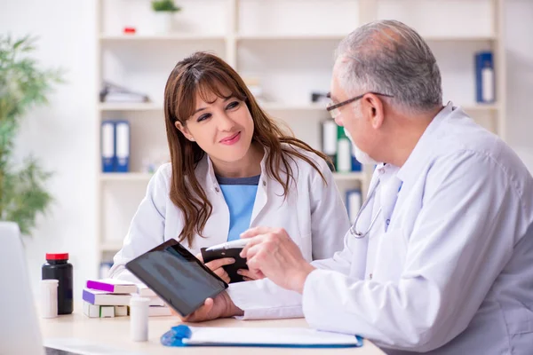 Yaşlı erkek doktor radyoloji uzmanı ve genç bayan asistanı. — Stok fotoğraf