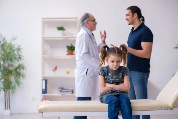 Junger Vater und seine Tochter zu Besuch beim alten Arzt — Stockfoto