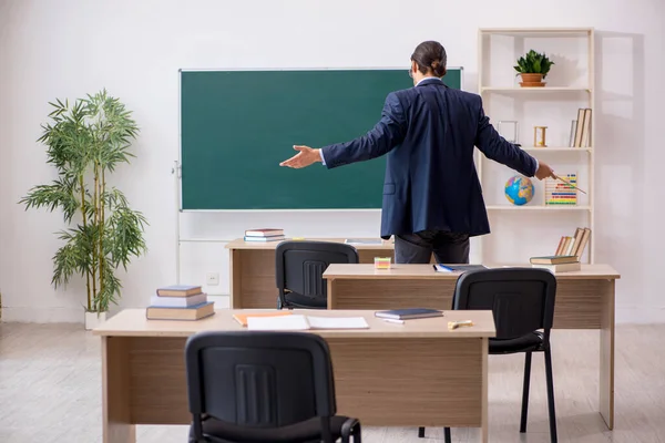 Junger männlicher Lehrer vor grünem Brett — Stockfoto