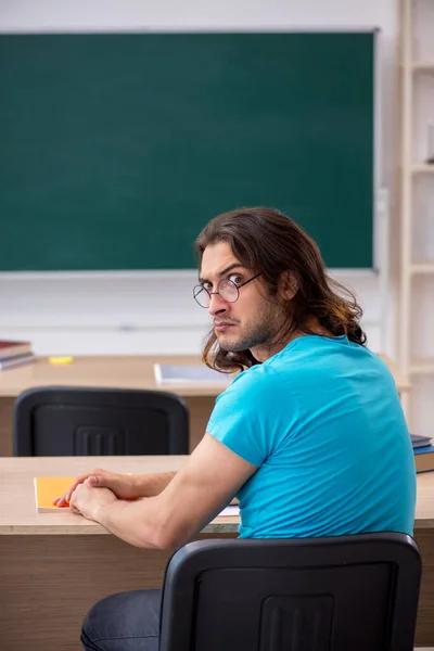 Jonge mannelijke student voor het groene bord — Stockfoto