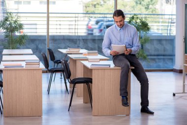 Sınıftaki genç erkek öğretmen.