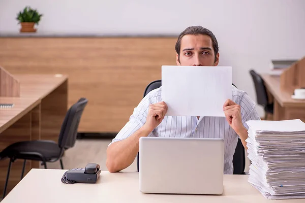 Jovem empregado do sexo masculino segurando em branco no escritório — Fotografia de Stock