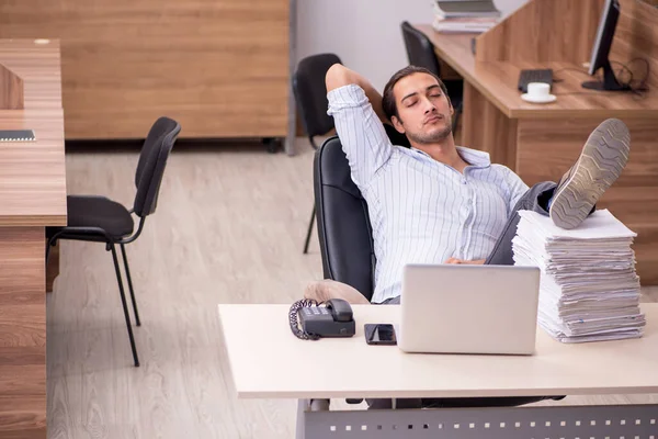 Joven empleado masculino infeliz con el trabajo excesivo — Foto de Stock