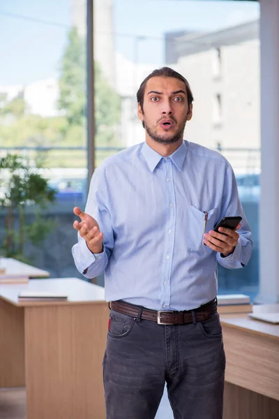 Young male teacher in the classroom — Stock Photo, Image