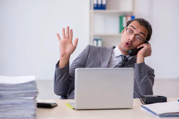 Ung manlig anställd pratar per telefon på kontoret — Stockfoto