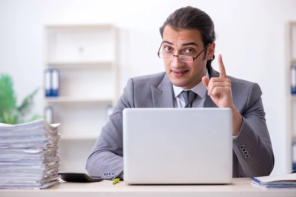 Jovem funcionário masculino infeliz com excesso de trabalho no escritório — Fotografia de Stock