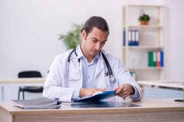 Klinikte çalışan genç erkek doktor.