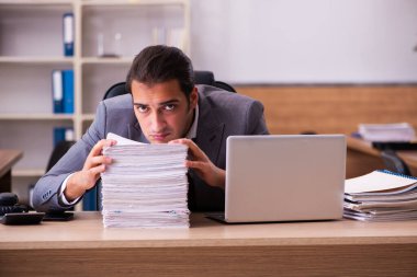 Genç erkek çalışan aşırı çalışmaktan son derece yoruldu.