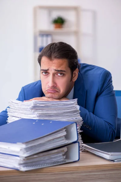Młody mężczyzna pracownik niezadowolony z nadmiernej pracy w biurze — Zdjęcie stockowe