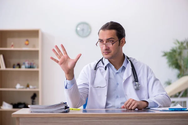 Jonge mannelijke arts werkzaam in de kliniek — Stockfoto