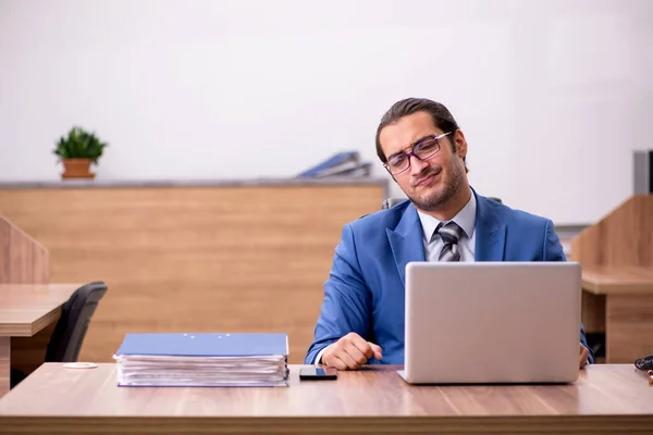 Mladý muž zaměstnanec sedí na pracovišti — Stock fotografie