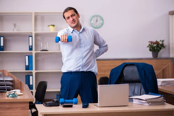 Junge männliche Mitarbeiter machen körperliche Übungen am Arbeitsplatz — Stockfoto