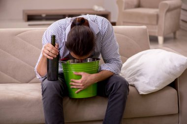 Genç sarhoş adam evde acı çekiyor.