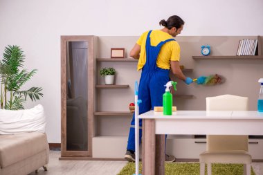 Genç erkek müteahhit evi temizliyor.