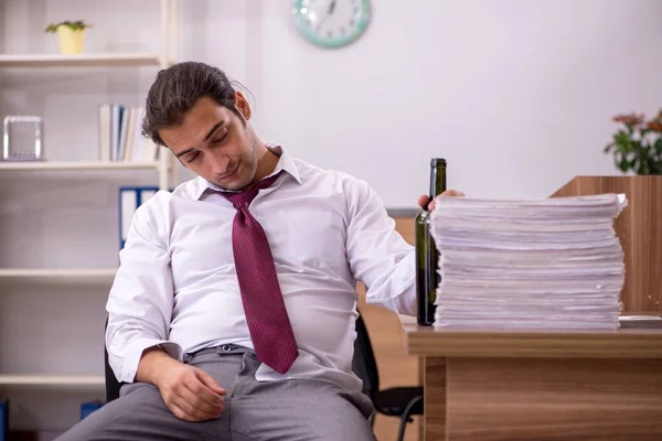 Ung manlig anställd dricker alkohol på kontoret — Stockfoto