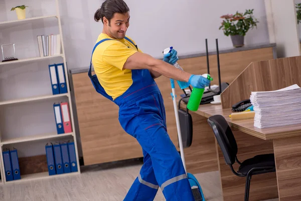 Joven contratista masculino limpiando la oficina — Foto de Stock