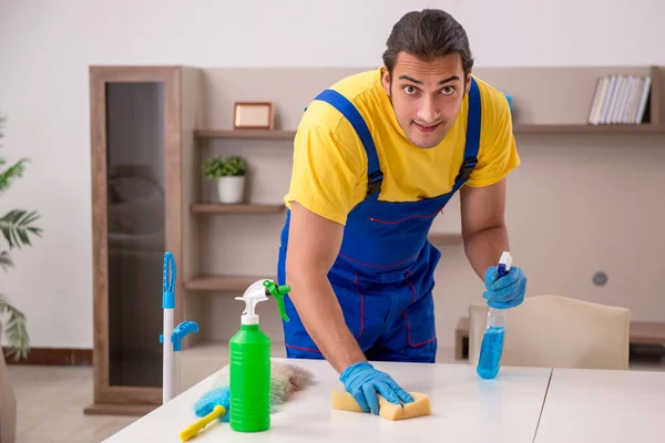 Jovem empreiteiro limpando a casa — Fotografia de Stock