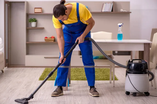 Joven contratista masculino limpiando la casa —  Fotos de Stock