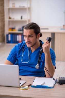 Klinikte çalışan genç erkek doktor.