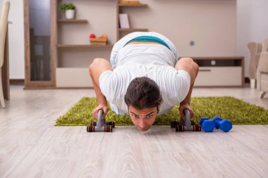 Genç adam evde spor yapıyor.