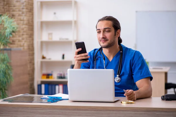 Ung manlig läkare som arbetar på kliniken — Stockfoto