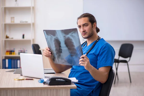 Ung manlig röntgenläkare som arbetar på kliniken — Stockfoto