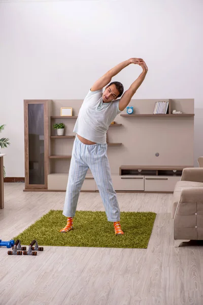 Молодий чоловік робить спортивні вправи вдома — стокове фото