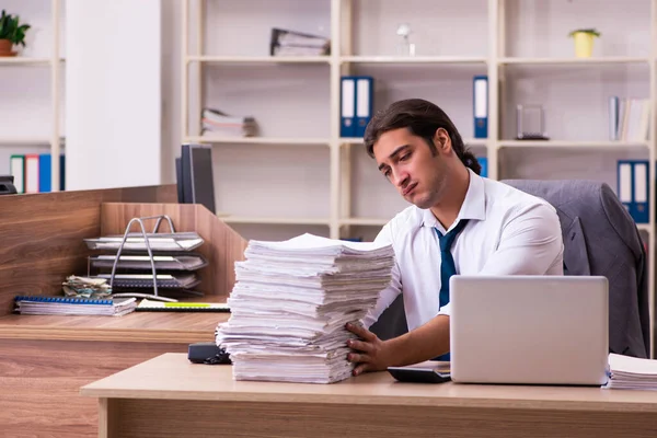 Jovem funcionário masculino infeliz com excesso de trabalho no escritório — Fotografia de Stock