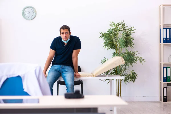 Young man waiting for doctor during pandemic in hospital — Stock Photo, Image