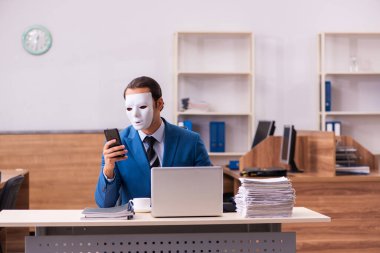 Ofiste maske takan genç bir erkek.