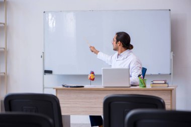 Genç erkek doktor sınıfta seminer veriyor.