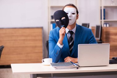 Ofiste maske takan genç bir erkek.